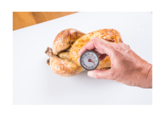 Someone using a probe thermometer to check the temperature of a cooked chicken.